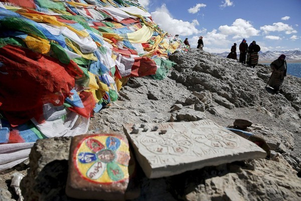 Người Tibet quây quần bên hòn đã được trang trí với những lá cờ cầu nguyện tại Hồ nước trên cao Namtso, khu tự trị Tibet. Namtso không chỉ nổi tiếng là một hồ nước mặn ở độ cao lớn nhất trên thế giới mà còn là điểm tâm linh thiêng liêng của người dân Tibet, thu hút vô cùng nhiều người sùng đạo hành hương về đây.