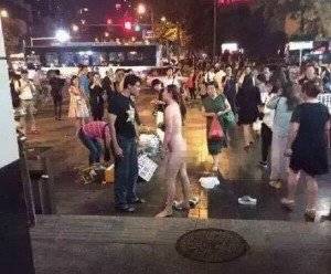 Cô gái cởi hết quần áo giữa chỗ đông người. (Nguồn: chinadaily)