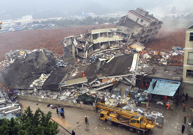 Rescuers search for survivors amongst collapsed buildings after a landslide in Shenzhen, in south China's Guangdong province, Sunday Dec. 20, 2015. The landslide collapsed and buried buildings at and around an industrial park in the southern Chinese city of Shenzhen on Sunday authorities reported. (Chinatopix via AP) CHINA OUT