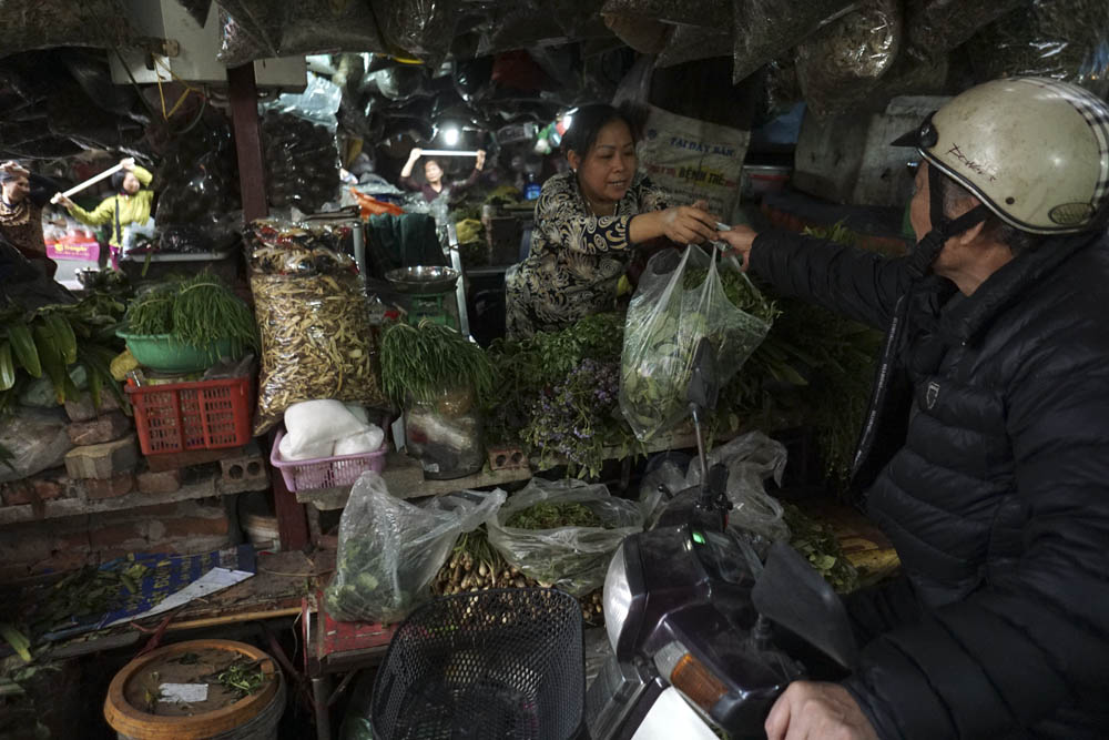 Vừa tập vừa bán hàng, Chị Vũ Thị Hiến (50 tuổi) cũng là một người tham gia tích cực với phong trào. Chị bán các loại lá xông trong chợ đã gần 30 năm nay