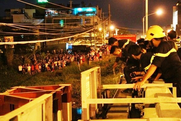 Hàng trăm người dân hiếu kỳ đứng xem cảnh sát cứu hội.