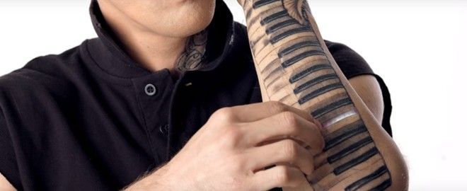 Hình xăm phím đàn piano và Aaron dùng tay để đàn.