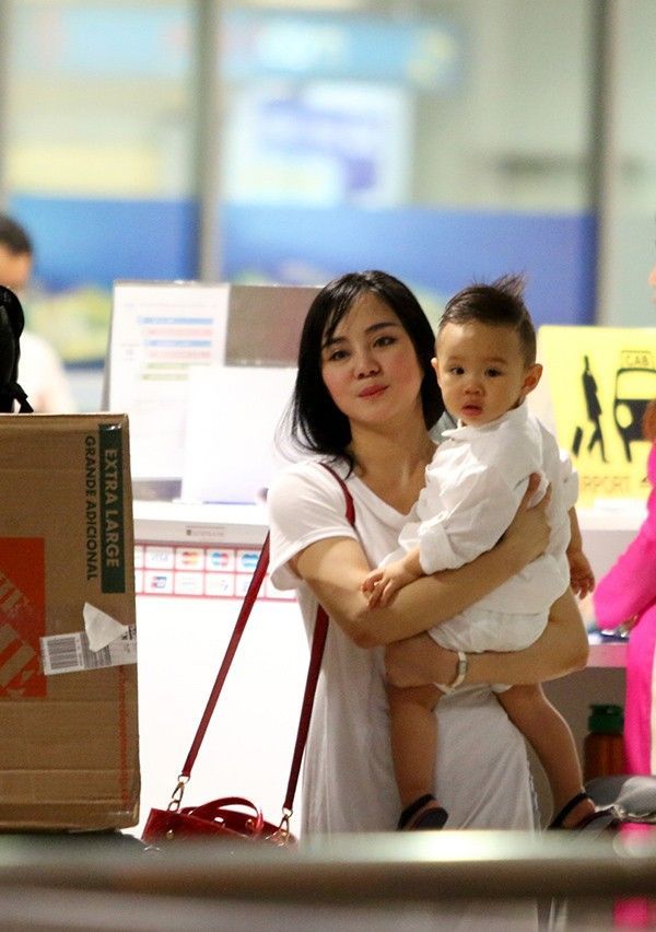 Sau khi lấy xong hành lý, Vy Oanh cùng con trai và người thân bước ra bên ngoài sảnh sân bay.