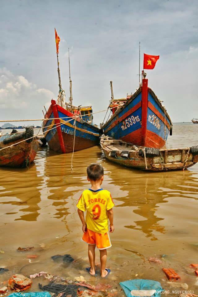 Trẻ em vui chơi quanh khu vực chứa đầy rác thải, trên mặt nước đục ngầu là những chiếc túi nilon.. 