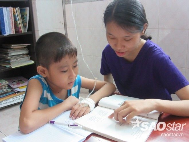 Một tình nguyện viên đang hướng dẫn các em đọc thơ.