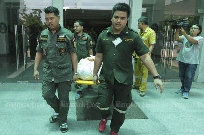 Cảnh sát đưa thi thể hai giảng viên đại học Phranakhon Rajabhat tới xe cứu thương hôm 18/5. Ảnh: Bangkok Post.