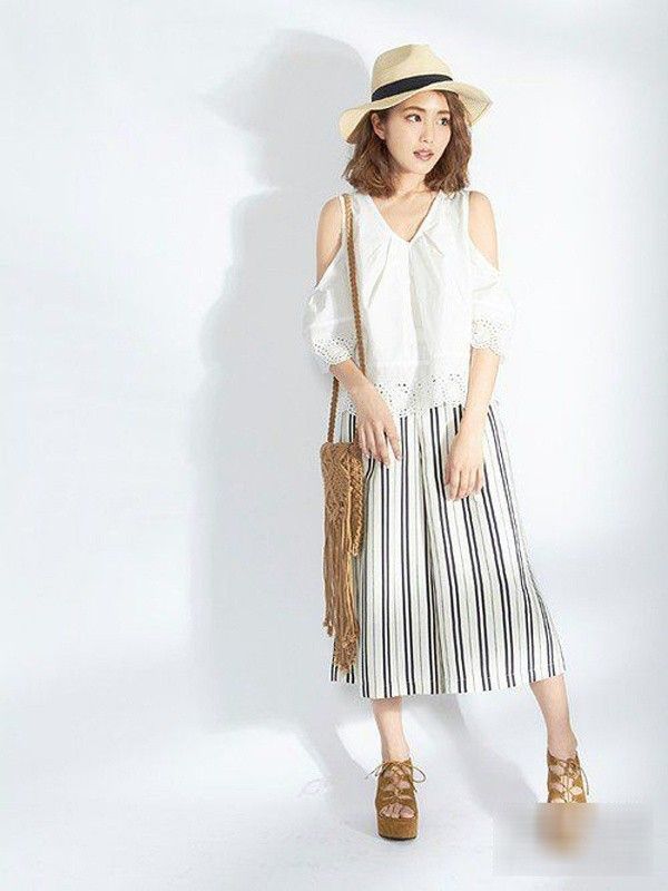 Áo khoét lỗ phần vai và quần ống rộng dáng ngắn cũng là item không thể thiếu nếu chuộng phong cách bohemian. Cũng đừng quên túi tua rua và giày cao gót tua rua nhé. 