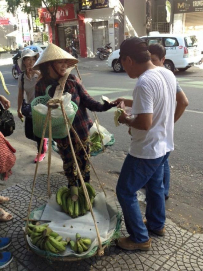 Người đàn ông Trung Quốc trả tiền Nhân dân tệ cho người bán chuối. 