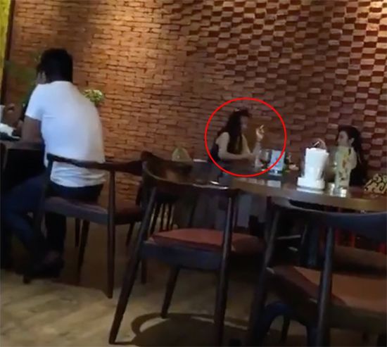 Kỳ Duyên ngồi hút thuốc trong quán cà phê cùng với một người bạn.