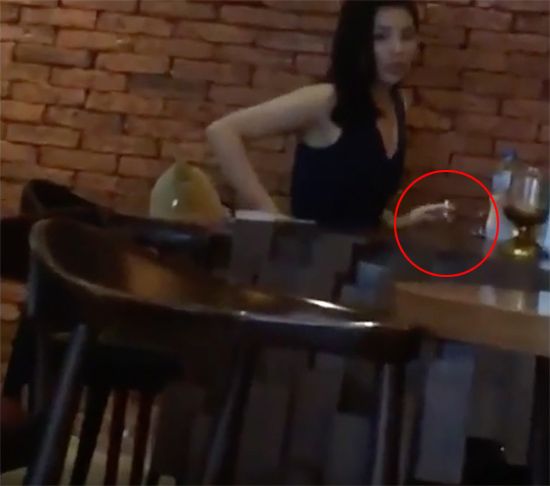 Hoa hậu Việt Nam cầm điếu thuốc lá trên tay.