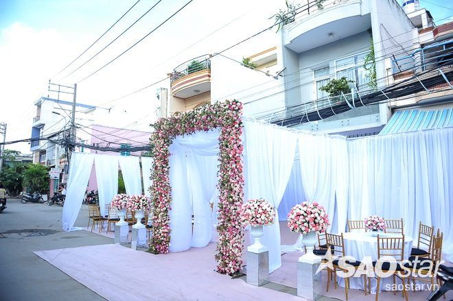 Cổng nhà cô dâu được trang trí bằng những dải lụa màu trắng làm chủ đạo.