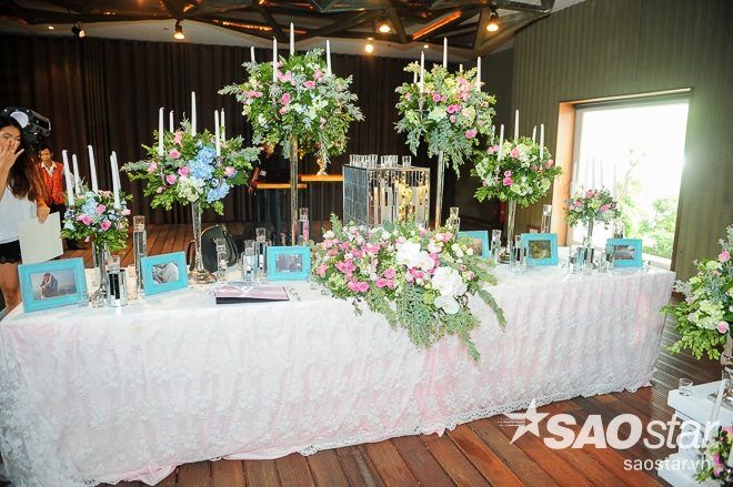 Không gian buổi tiệc được trang trí sang trọng với hoa ly và hoa lan, điểm thêm sắc hồng của những bông hoa hồng dịu dàng.