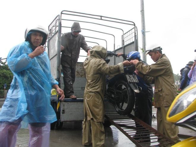 Huy động xe ô tô tải chở các phương tiện xe máy qua cầu để đảm bảo an toàn.