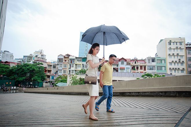 Tú Anh đội mưa bão di chuyển vào trong trường quay.