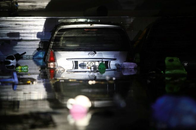 Toà nhà nơi ngân hàng VPBank hoạt động có 2 chiếc ôtô chìm hẳn trong nước. Hai xe khác ở tầng hầm trên bị ngập một phần.