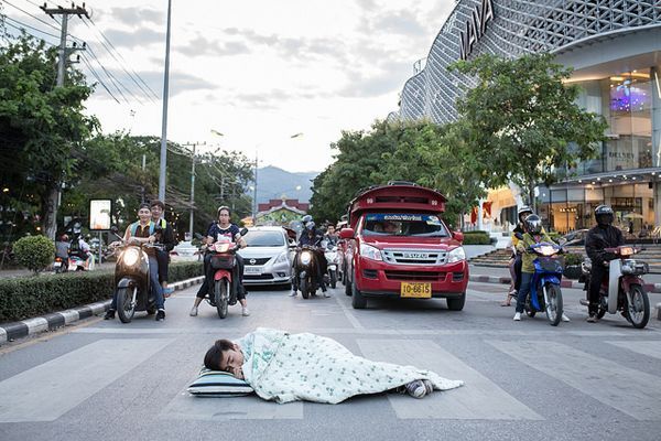 Bức ảnh chàng trai mang chăn, gối ra ngủ giữa đường.