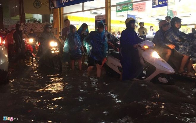 Mưa đúng giờ tan tầm khiến nhiều người di xe máy vất vả. Ảnh: Đức Phạm.