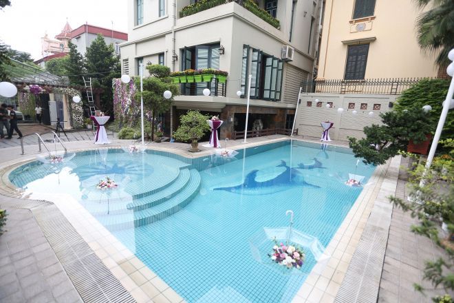 Không gian có sẵn được tận dụng tối đa, ví dụ như bể bơi được Wedding planner sáng tạo thả những bông hoa vào những chiếc ô trong suốt nổi bồng bềnh trên mặt nước tăng sự lãng mạn cho không gian ngày trọng đại.