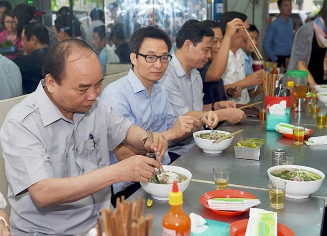 Thủ tướng và đoàn kiểm tra dừng chân, dùng điểm tâm tại một quán ăn đường phố thuộc phường Tân Thành, TPHCM. Ảnh: VGP/Quang Hiếu.