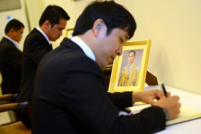 Mọi người lần lượt ghi sổ tang bên chân dung của đức vua.