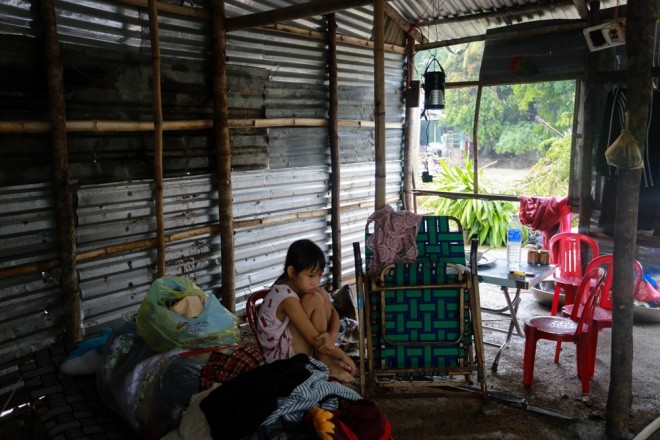 Em Nguyễn Uyên Hoài Nhớ (9 tuổi) ngồi thu lu trong căn nhà của hàng xóm. Còn cha mẹ em đang phải thu dọn, sửa lại căn nhà bị lũ làm hư hỏng cách đó vài chục mét. "Lũ về trong đêm, mọi người chạy tán loạn. Con sợ lắm", Nhớ kể. 