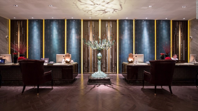 Quầy lễ tân với các bức tường bọc da cá đuối nhuộm màu xanh dương làm nổi bật bức tượng đồng “Vùng đất thần tiên” của tác giả Wei Dong.