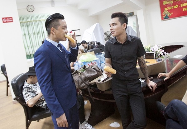 Tuấn Hưng và Khắc Việt vội vã ăn bánh mì trước khi lên sân khấu biểu diễn.