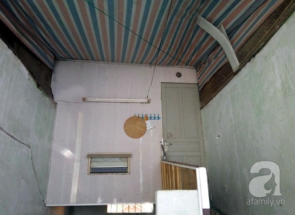 Một gia đình trên tầng 2 phải dùng bạt che chắn mưa và tránh bụi bẩn rơi xuống.