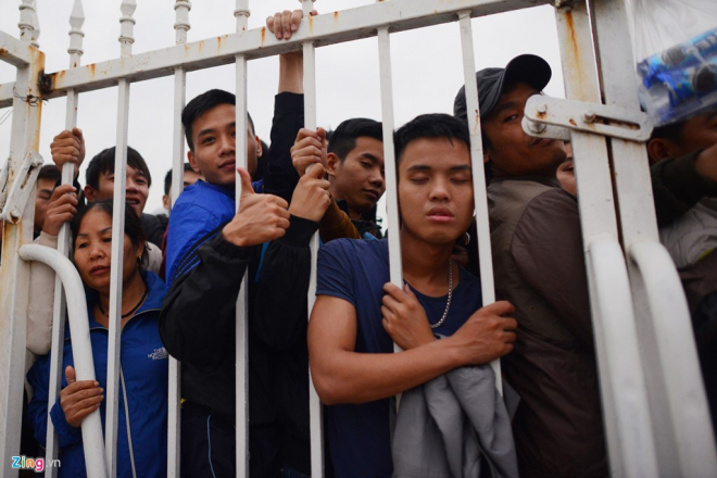 Một thanh niên mệt mỏi ngủ gà gật trong khi đứng xếp hàng.