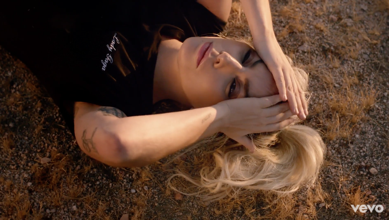 Gaga xuất hiện ngay đầu MV trong dáng vẻ mệt mỏi nằm giữa sa mạc.