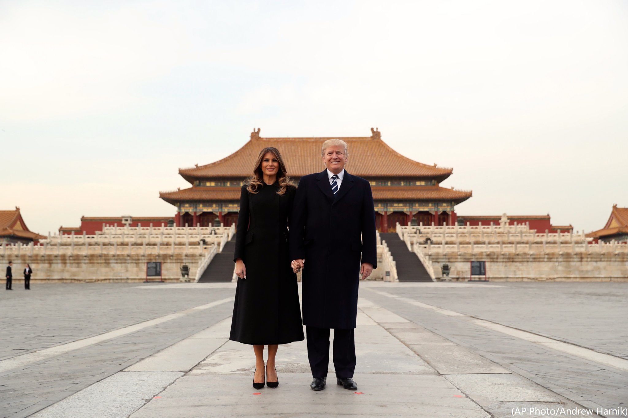 Vợ chồng Tổng thống Donald Trump chụp ảnh trước Tử Cấm Thành, trên người bà Melania lúc này là chiếc áo choàng Dior tối màu cùng đôi giày cao gót mũi cao.
