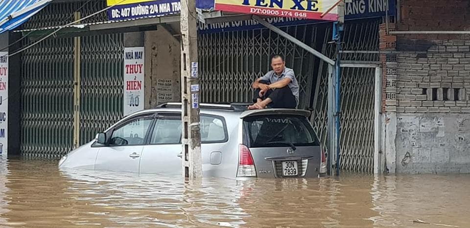 Tài xế ô tô phải leo lên nóc xe tránh ngập trên đường 2/4 (Nha Trang) - Ảnh: Facebook.