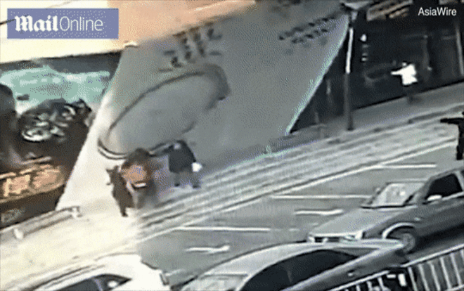 Đang đi đường bất ngờ bị bảng hiệu khổng lồ đổ sập vào người Ảnh 2