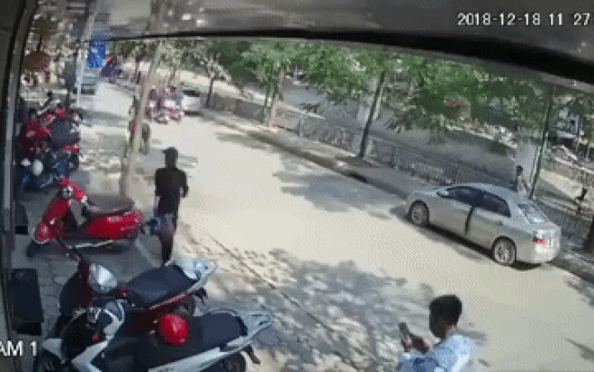 Tài xế Vios mở cửa không để ý khiến nam thanh niên đi xe máy ngã ra đường và nằm gọn trong gầm ô tô tải Ảnh 2