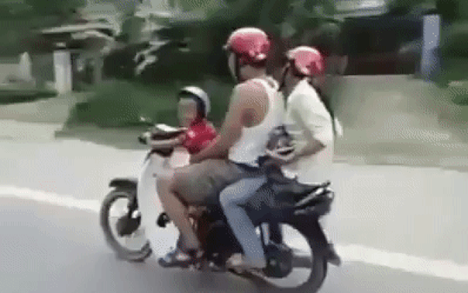 CLIP: Cho con trai nhỏ tuổi liều lĩnh cầm lái xe máy, cha mẹ ngồi sau còn cười đùa vui vẻ Ảnh 2