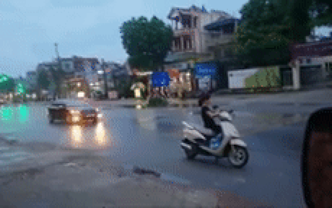 Người phụ nữ dựng chân chống xe máy giữa đường, thảnh thơi lướt điện thoại mặc kệ xe cộ qua lại ầm ầm Ảnh 2