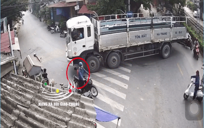 Giật mình cảnh chiếc xe tải đang chầm chậm ôm cua, bất ngờ một phụ nữ chạy ra nằm ngay bánh xe Ảnh 2