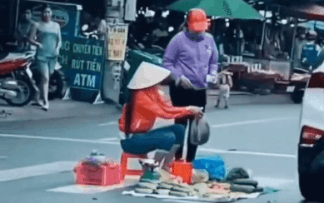 Clip: Ngao ngán cảnh người phụ nữ mang rau bày trên vạch kẻ đường rồi thản nhiên ngồi bán Ảnh 2