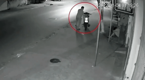 Thấy nam thanh niên ngủ say sưa, người đàn ông mau chóng điều khiển xe máy rời đi. Ảnh cắt từ clip