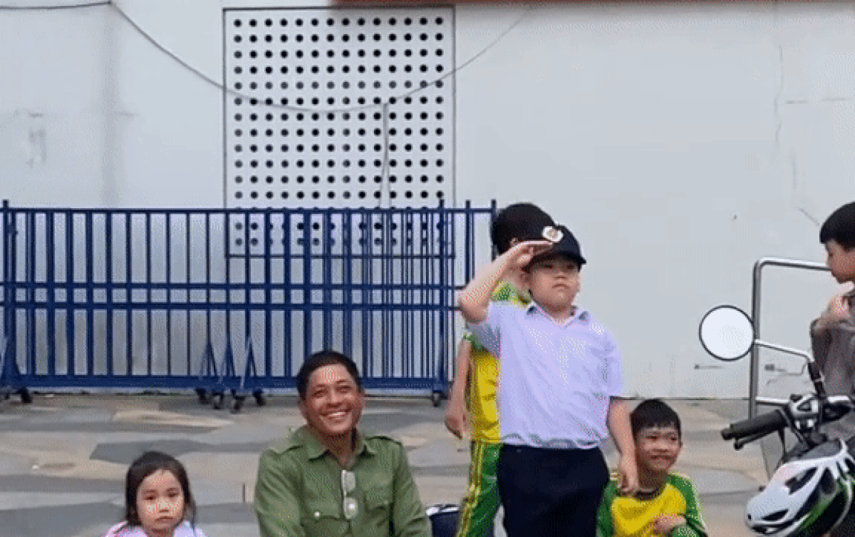 Bác bảo vệ ngồi bệt xuống đường, vừa chơi đùa vừa cùng học sinh đợi phụ huynh đến đón về Ảnh 2