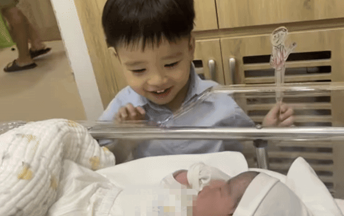 Tan chảy với biểu cảm của bé trai khi lần đầu gặp em gái mới chào đời Ảnh 2