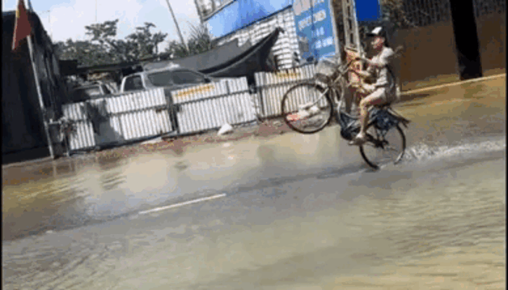 Nam thanh niên có màn trình diễn táo bạo giữa đường phố ngập lụt. Ảnh cắt clip. (Nguồn: JQuyn)