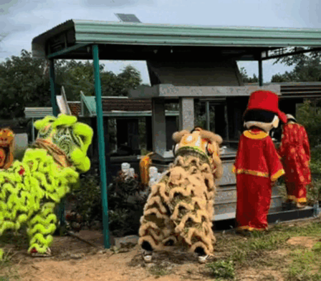 Người bố trẻ ở Gia Lai mời đội múa lân đến biểu diễn trước mộ phần của cậu con trai. Ảnh cắt từ clip. (Nguồn: Bố và Tôm)