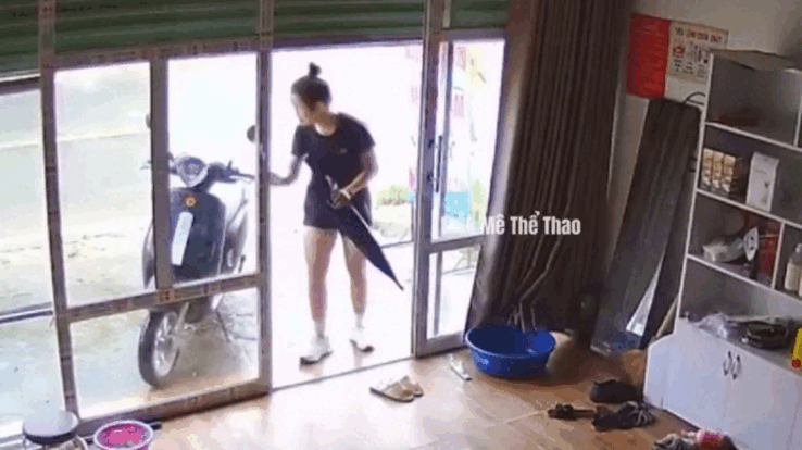 Cô gái mở cửa kính và dắt xe vào nhà. Ảnh cắt từ clip. (Nguồn: F168 Thể Thao)