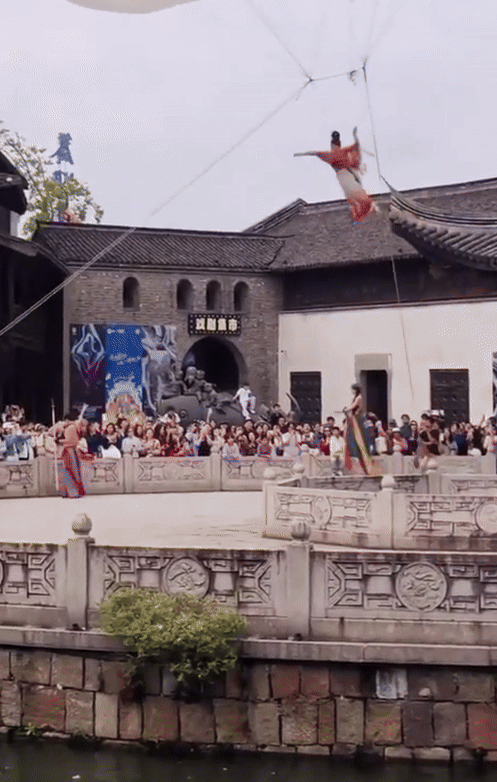 Nữ diễn viên múa thực hiện động tác trên không trung, trước sự chứng kiến của hàng trăm khán giả. (Ảnh từ Weibo)