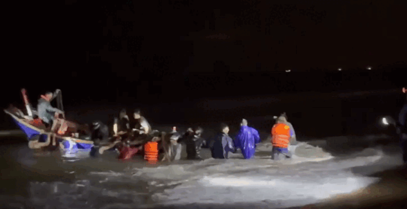 Chính quyền và người dân kéo dắt thuyền cá và ngư dân gặp nạn vào bờ. (Nguồn: Báo Sài Gòn Giải Phóng)