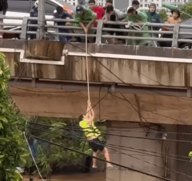 Người dân thả dây thừng cứu người gặp nạn. Ảnh cắt từ clip. (Nguồn: VnExpress)