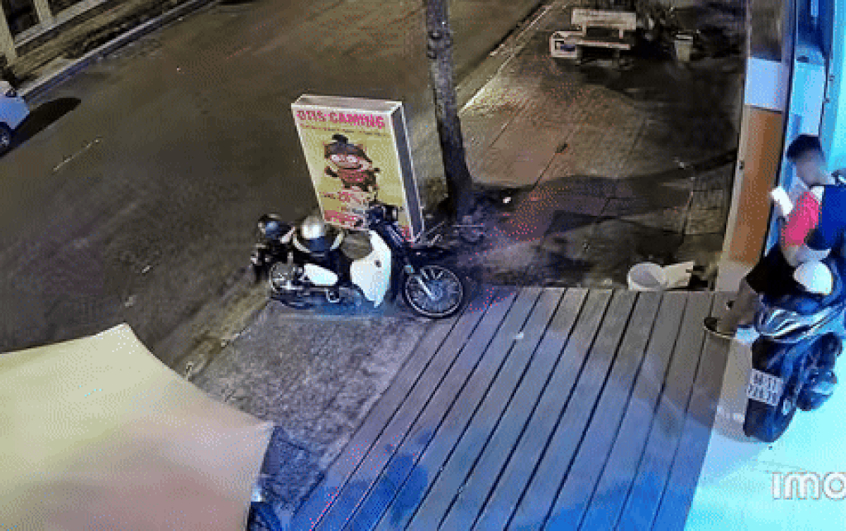 Thanh niên tông trúng xe máy dựng bên đường, làm văng các túi thịt đã mua trước đó. Ảnh cắt từ clip