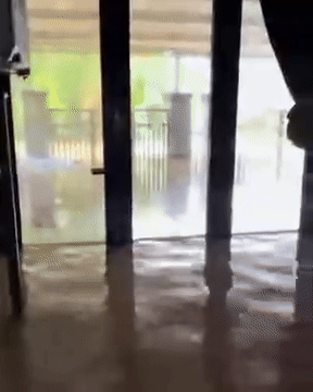 Cô gái gội đầu giữa dòng nước ngập.