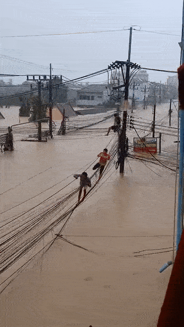 Người dân liều mình đi trên dây điện để thoát thân giữa dòng lũ khiến mạng xã hội xôn xao Ảnh 4